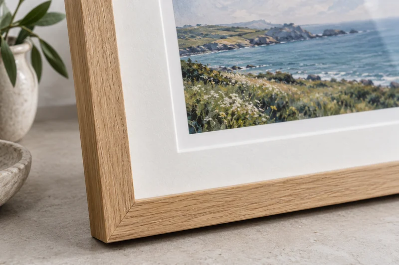 Close detail of an oak frame mitre and the bevelled edge of a white picture mount