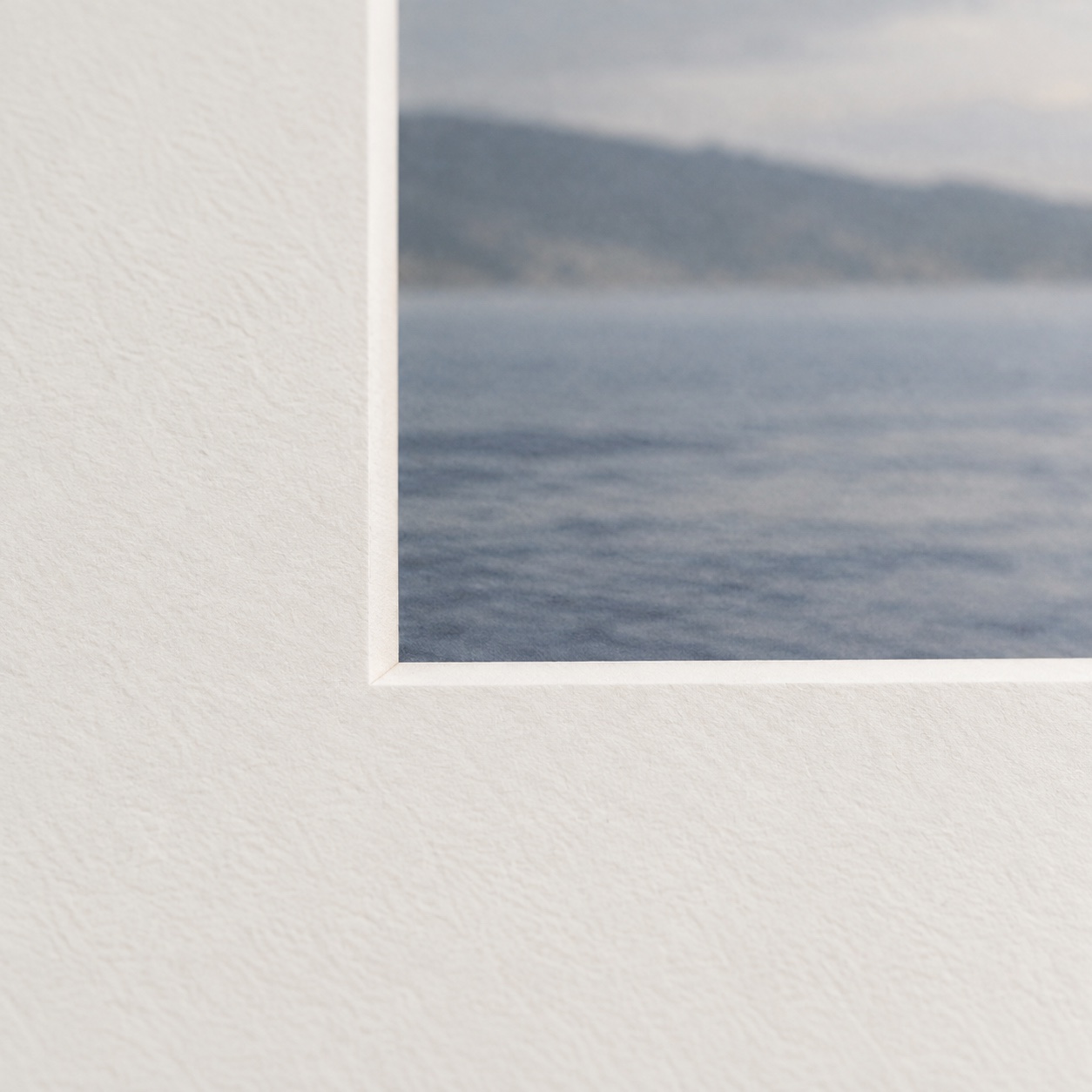Close-up of the fine white bevel and paper texture around a picture mount opening